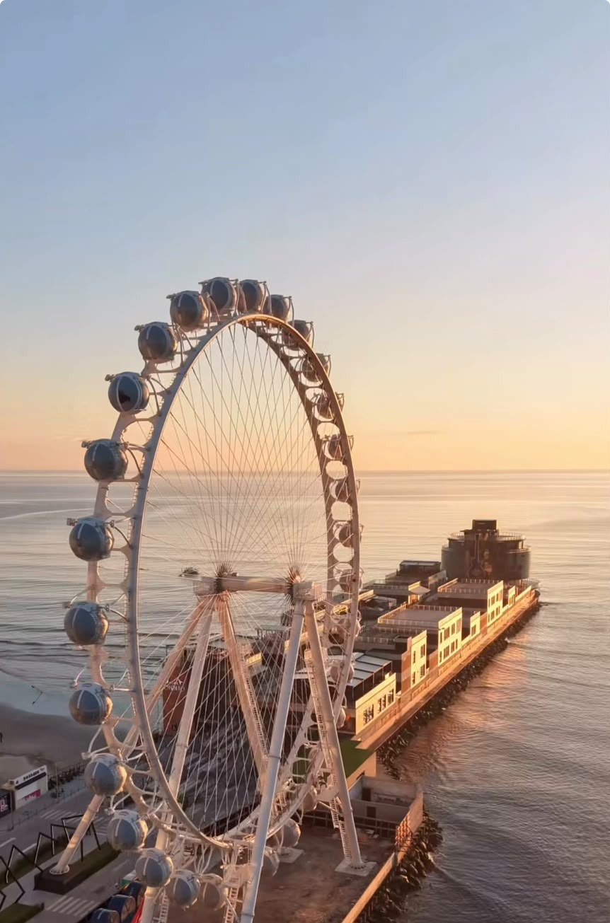 Vista de Itapema ao pôr do sol, com a roda-gigante e o píer à beira-mar